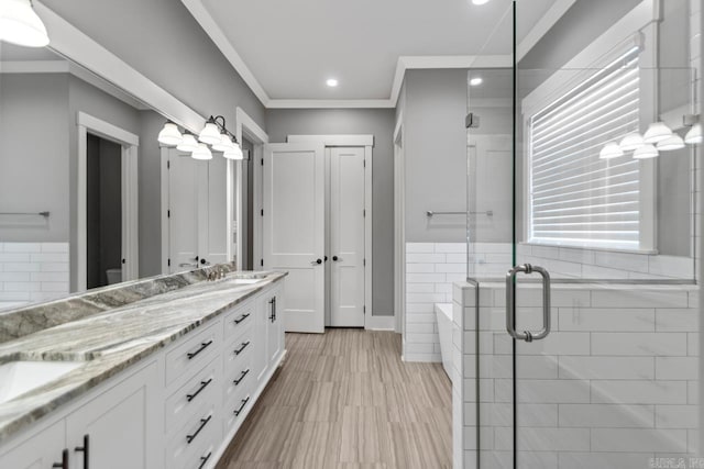 bathroom with vanity, an enclosed shower, and ornamental molding