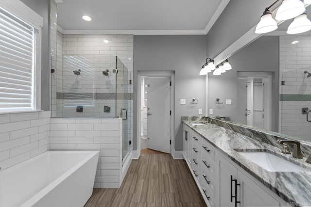 bathroom with hardwood / wood-style floors, vanity, ornamental molding, and shower with separate bathtub