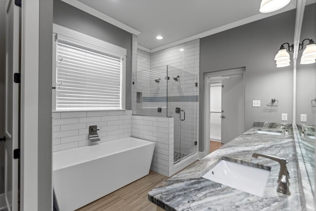 bathroom with plus walk in shower, wood-type flooring, and vanity