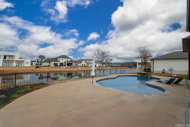 view of pool featuring a water view and a patio