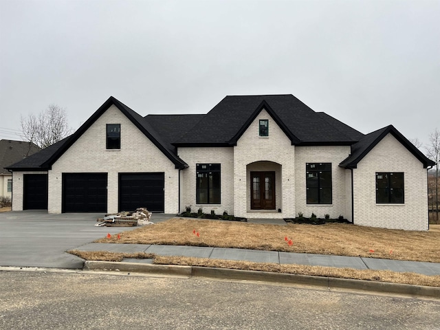 french provincial home featuring a garage and french doors