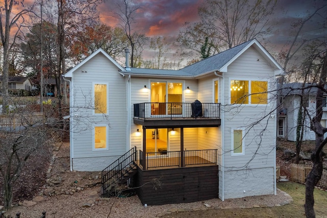 back house at dusk with a balcony