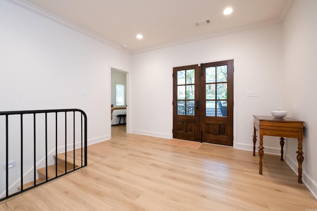 foyer entrance featuring french doors, light hardwood / wood-style floors, and crown molding