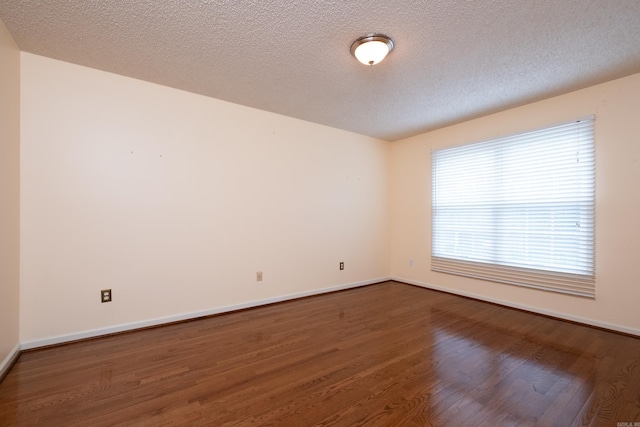 empty room with hardwood / wood-style flooring and a textured ceiling