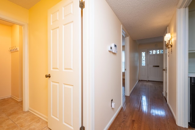 corridor with hardwood / wood-style flooring and a textured ceiling