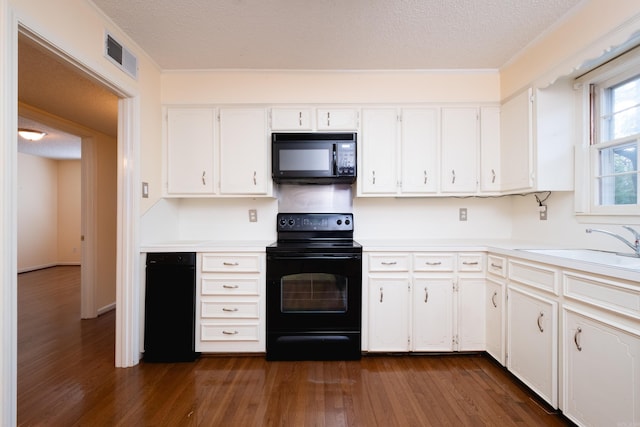 kitchen featuring white cabinets, a textured ceiling, dark wood-type flooring, and black appliances