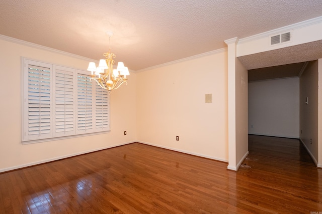 empty room featuring a chandelier, crown molding, dark wood-type flooring, and a textured ceiling