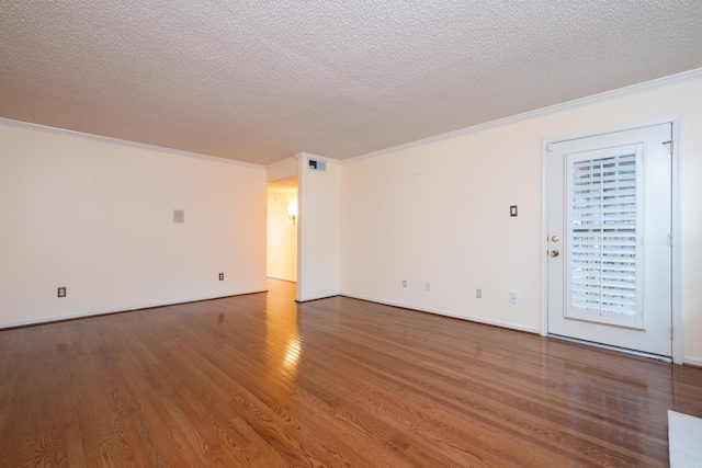 empty room featuring a textured ceiling, hardwood / wood-style flooring, and crown molding