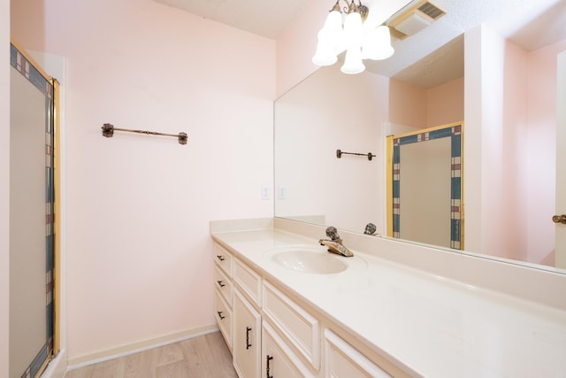 bathroom featuring hardwood / wood-style floors, vanity, and an enclosed shower