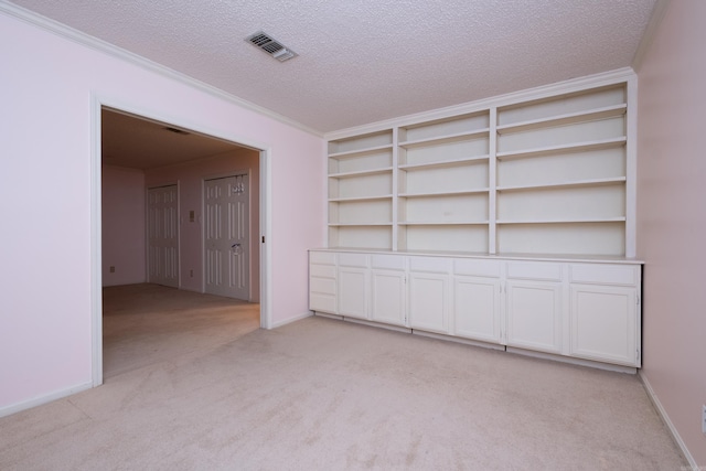 interior space featuring ornamental molding and a textured ceiling