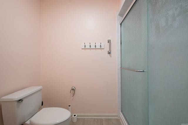 bathroom with hardwood / wood-style floors, toilet, and walk in shower