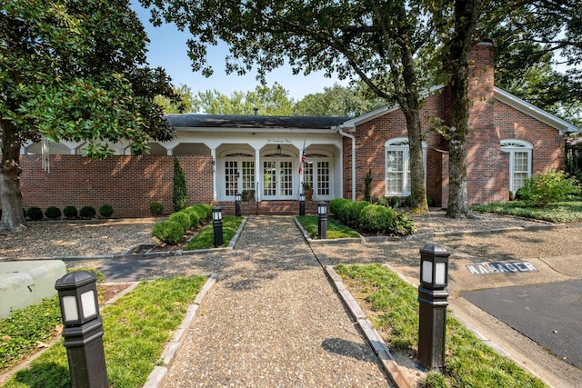 view of front of house featuring covered porch and french doors