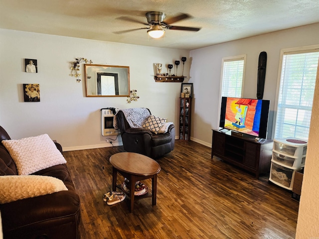 living room featuring heating unit, ceiling fan, dark hardwood / wood-style flooring, and a textured ceiling