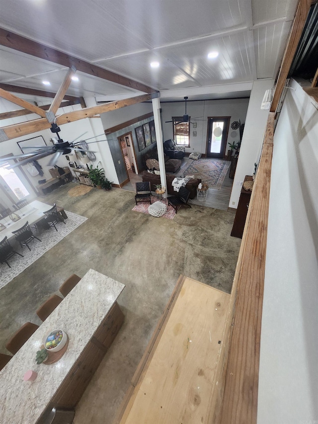 dining room featuring beamed ceiling and concrete flooring