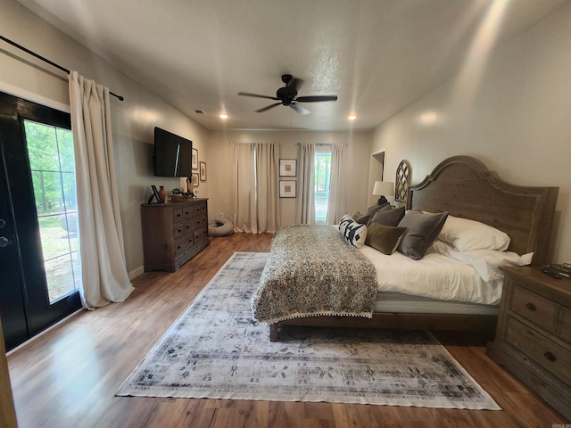 bedroom featuring multiple windows, ceiling fan, and hardwood / wood-style flooring