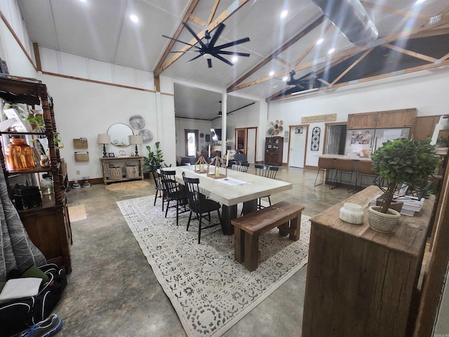 dining area with ceiling fan, high vaulted ceiling, and concrete floors