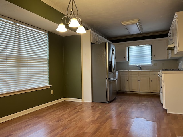 kitchen featuring hanging light fixtures, stainless steel refrigerator with ice dispenser, a notable chandelier, crown molding, and stove