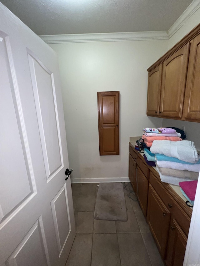 washroom with dark tile patterned floors and ornamental molding