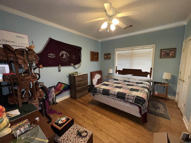 bedroom featuring ceiling fan, hardwood / wood-style floors, and crown molding