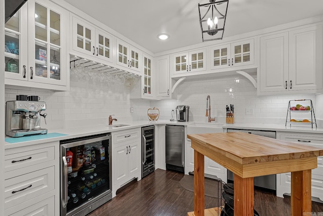 kitchen with backsplash, white cabinetry, dark wood-type flooring, and beverage cooler