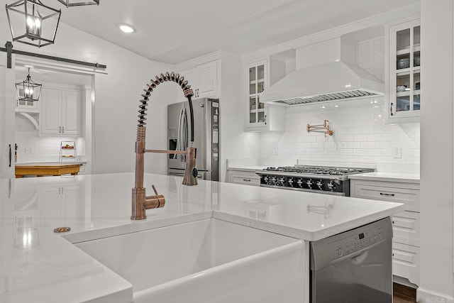 kitchen with premium range hood, white cabinetry, decorative light fixtures, and appliances with stainless steel finishes