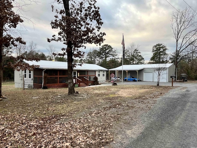 view of front of house with covered porch, a garage, and an outdoor structure