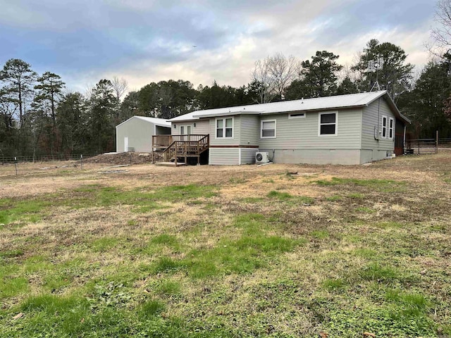 rear view of property featuring a lawn and a wooden deck