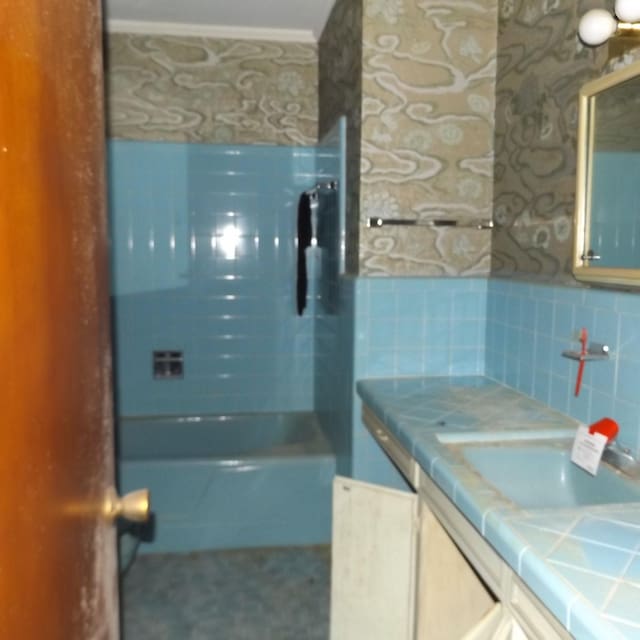 bathroom with tasteful backsplash, vanity, and bathing tub / shower combination