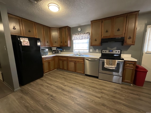 kitchen with dark hardwood / wood-style flooring, stainless steel appliances, a textured ceiling, and sink