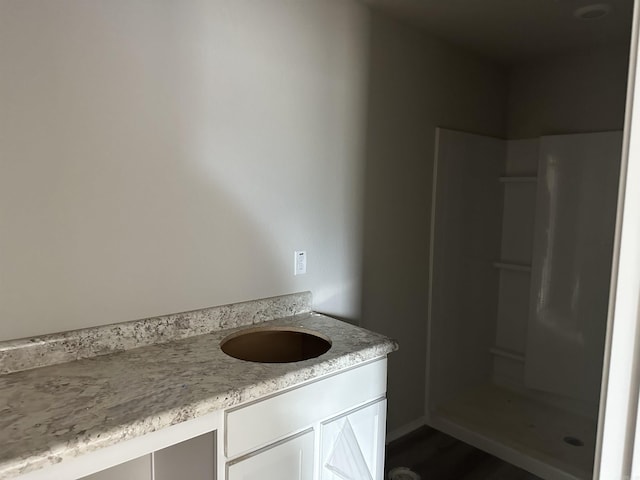 bathroom featuring walk in shower and vanity