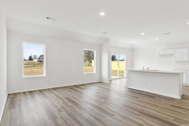 unfurnished living room featuring light hardwood / wood-style flooring and sink