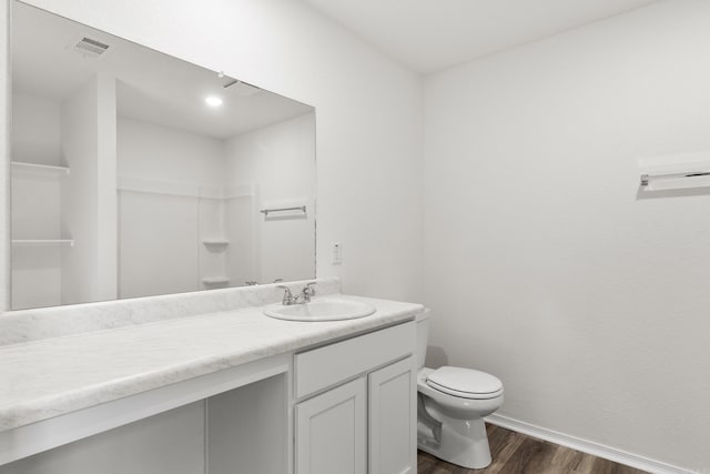 bathroom with toilet, hardwood / wood-style flooring, a shower, and vanity