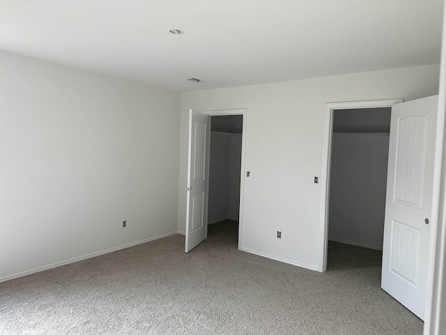 unfurnished bedroom featuring carpet floors, a closet, and a walk in closet