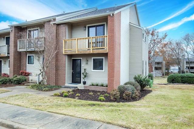 multi unit property featuring a balcony and a front yard