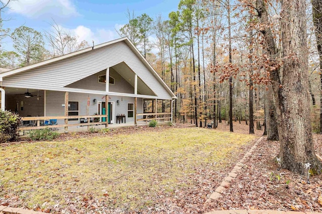 exterior space featuring covered porch, ceiling fan, and a lawn