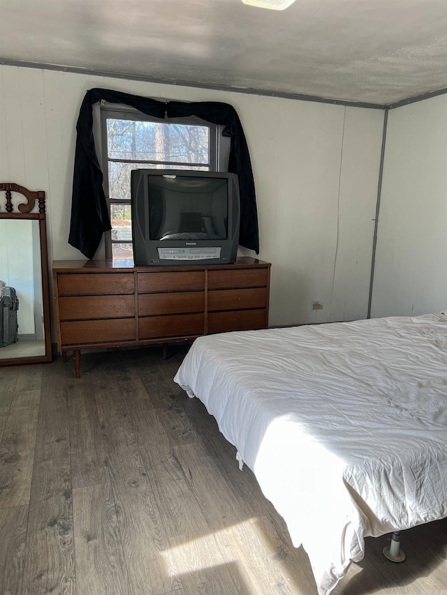 bedroom featuring wood-type flooring and wooden walls