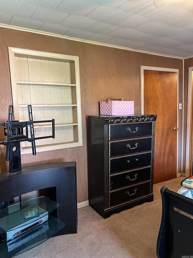 carpeted bedroom with crown molding and wooden walls