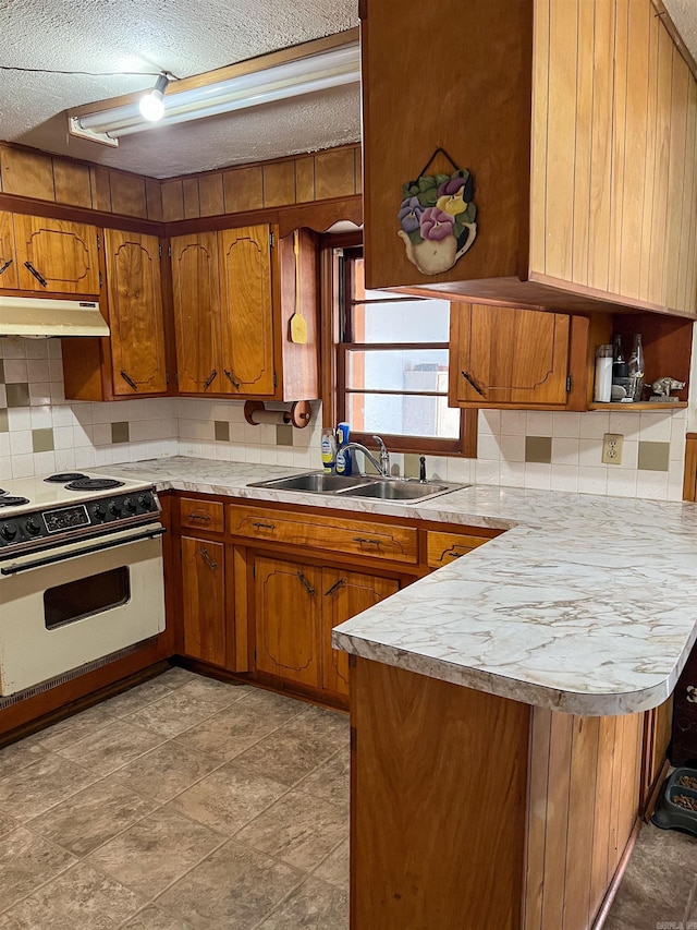 kitchen with sink, white range oven, kitchen peninsula, a textured ceiling, and decorative backsplash