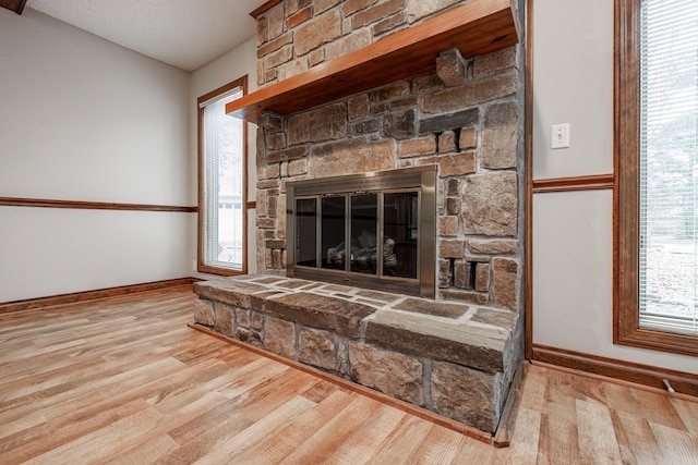 interior details featuring a fireplace, a textured ceiling, and hardwood / wood-style flooring