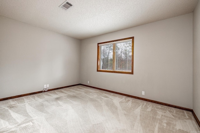 carpeted spare room with a textured ceiling