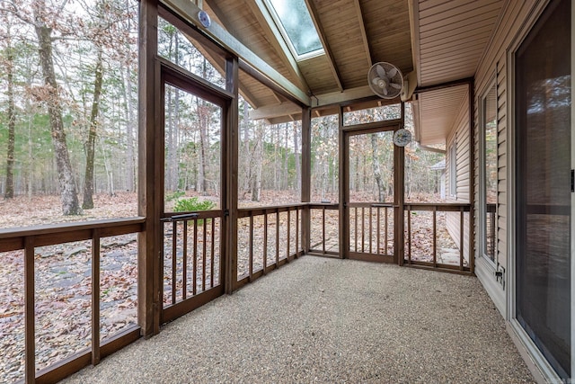 unfurnished sunroom with vaulted ceiling with skylight and wooden ceiling