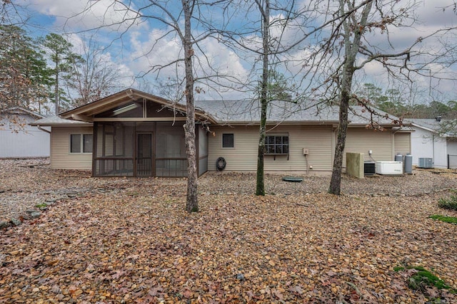 rear view of property featuring a sunroom and central air condition unit