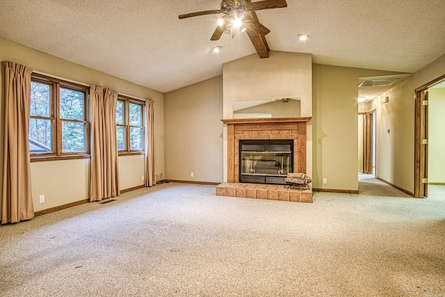 unfurnished living room with a tiled fireplace, ceiling fan, carpet floors, and lofted ceiling with beams