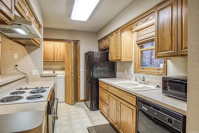 kitchen featuring black appliances, a textured ceiling, sink, and washing machine and clothes dryer