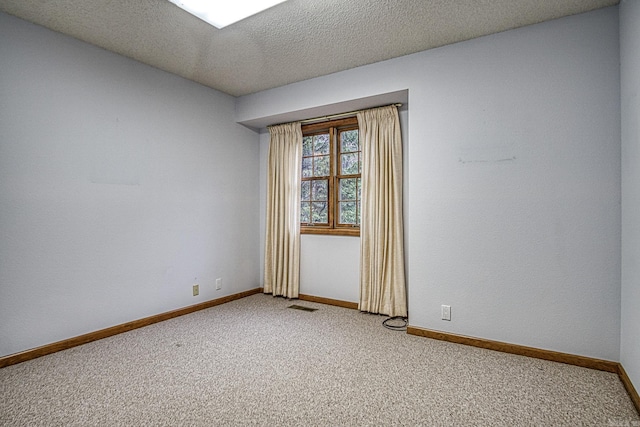 carpeted spare room featuring a textured ceiling