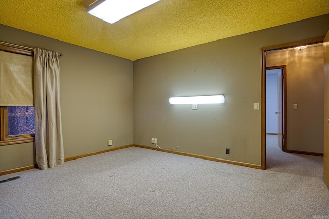 carpeted empty room with a textured ceiling