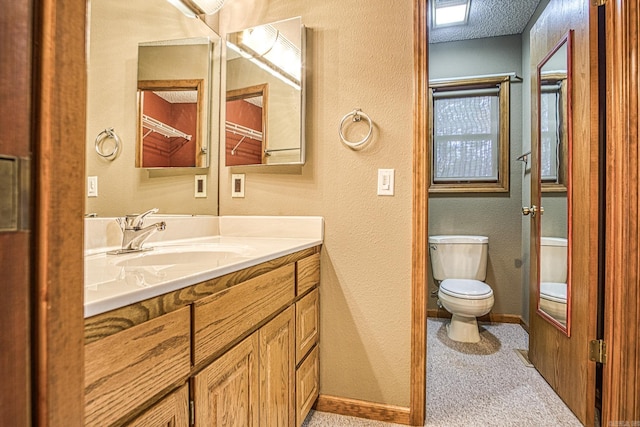 bathroom featuring vanity, a textured ceiling, and toilet