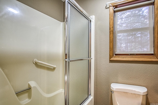 bathroom featuring bath / shower combo with glass door and toilet