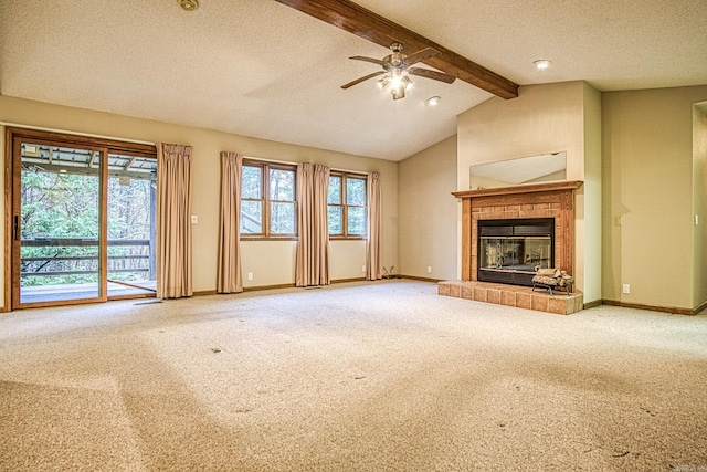 unfurnished living room featuring lofted ceiling with beams, carpet floors, a textured ceiling, and a tile fireplace