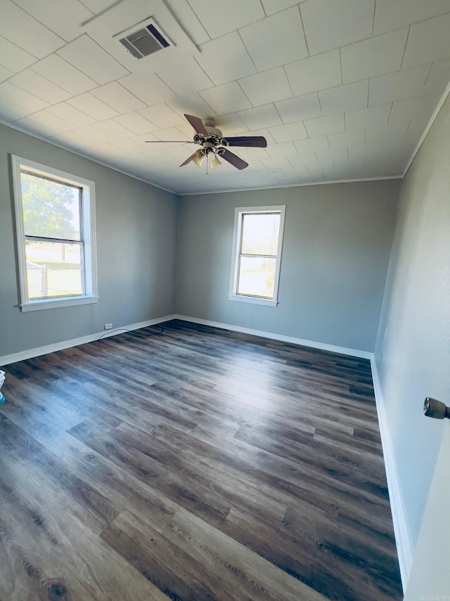 unfurnished room featuring ceiling fan, dark hardwood / wood-style floors, ornamental molding, and a healthy amount of sunlight